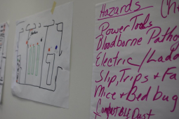 Flipcharts on the wall list workplace hazards including combustible dust and bloodborne pathogens