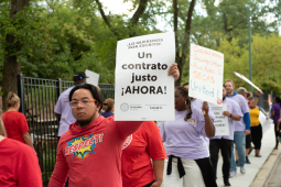 A CTU member holds a sign reading: "Fair contract now!" in Spanish