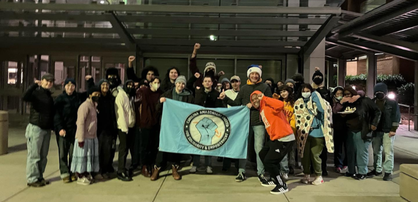 Amazon workers and community supports gather holding an Amazon CAUSE banner. 