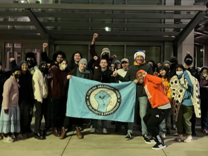 Amazon workers and community supports gather holding an Amazon CAUSE banner. 