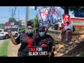 Two CWA members with signs for Black lives on the pavement