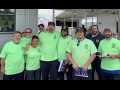 Group of workers in matching green T-shirts outside the plant