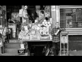 Produce seller with his sidewalk stand in Chinatown, New York, in front of store