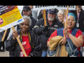 Postal workers march with signs about working conditions.