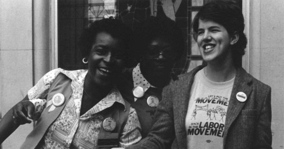 Multiracial group of activists standing next to each other and laughing.