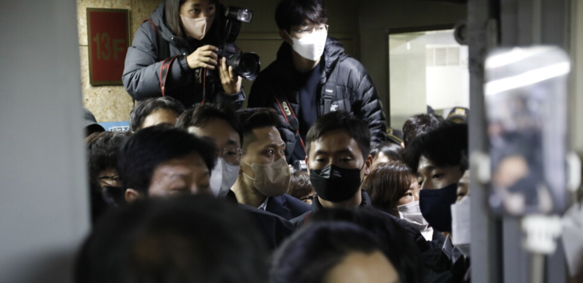 People and photographers gather at KCTU headquarters during the raid.