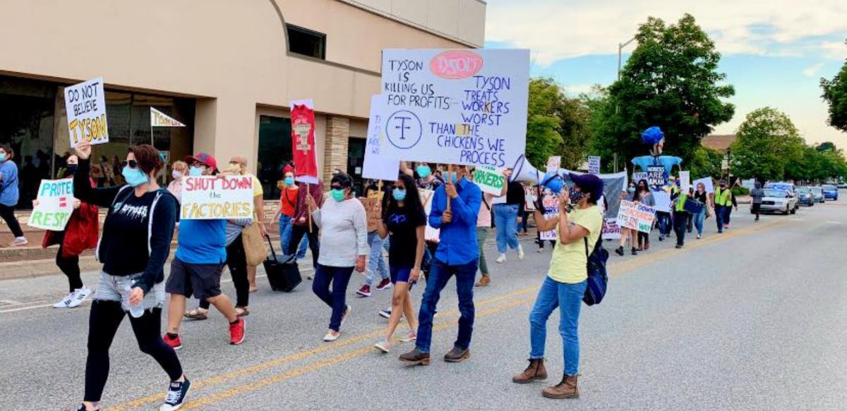 Masked people march with signs: "Tyson Is Killing Us for Profits. Tyson Treats the Workers Worst than the Chickens We Process." "Don't Believe Tyson." "Shut Down the Factories." "Protect = Respect." 