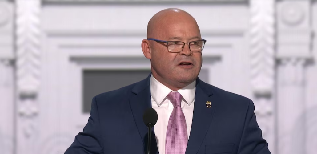 Screenshot of O'Brien, a white man in a suit, wearing a Teamsters lapel pin, speaking at the convention