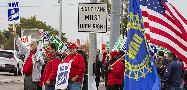 UAW strikers picketing on a street corner.