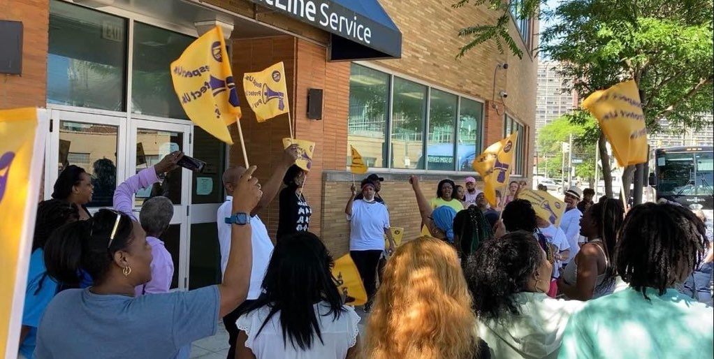 Workers with flags gather outside the glass-doored offices of Frontline in Cleveland