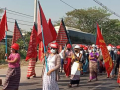 Women marching in the streets with red flags in Burma.