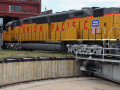 An orange Union Pacific railroad locomotive is shown in a repair area.