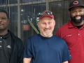 Three smiling men, two African American, one European American, face the camera