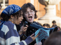 two young people address a crowd in what appears to be a campus setting