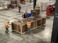 Several workers work around a crate with black-colored mold visible on the lid