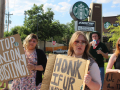 Striking Starbucks workers and supporters hold signs reading Stop Union Busting outside a store.