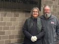 A couple stand by a wall with a Hyatt sign