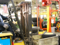 A worker drives a forklift inside a John Deere plant